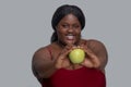 Plus size african american young woman in red holding an apple and smiling Royalty Free Stock Photo