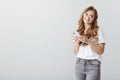 Feeling great in friends circle. Ordinary happy european female student in glasses and casual clothes, holding Royalty Free Stock Photo