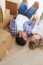 Feeling at home. A happy young couple looking at each other lovingly while lying on the floor in their new home. Royalty Free Stock Photo