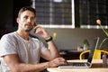 Feeling an idea forming. a handsome young man using a laptop and talking on his cellphone in a cafe. Royalty Free Stock Photo