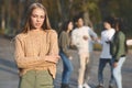 Frustrated blondy girl standing over group of teenagers Royalty Free Stock Photo