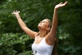 Feeling at one with nature. A pretty young woman with her arms raised while standing in a forest. Royalty Free Stock Photo