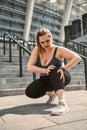 Feeling pain after workout. Young plus size woman touching her knee and feeling pain after sport training while standing Royalty Free Stock Photo