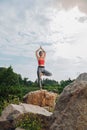 Slim and fit woman feeling peaceful while doing yoga pose