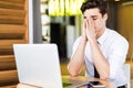 Feeling sick and tired, Frustrated young man massaging his nose and keeping eyes closed while sitting at his working place in offi Royalty Free Stock Photo