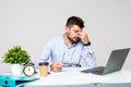 Feeling sick and tired. Frustrated young man massaging his nose and keeping eyes closed while sitting at his working place in Royalty Free Stock Photo