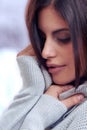 Feeling the softness. a beautiful brunette looking demure in winter.