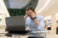 Feeling tired. Frustrated young man covering his face with hands while working on laptop Royalty Free Stock Photo