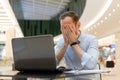 Feeling tired. Frustrated young man covering his face with hands while working on laptop Royalty Free Stock Photo