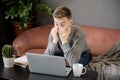 Feeling tired.Frustrated young  man student looking exhausted and covering his face with hands while sitting at laptop Royalty Free Stock Photo