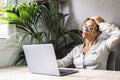 Feeling tired and stressed. Frustrated mature woman keeping eyes closed and touching head while sitting at her working place in Royalty Free Stock Photo