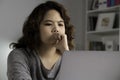 Feeling tired and stressed. Young Asian woman sitting looking deep in thought exhausted and tired during working at home office us Royalty Free Stock Photo