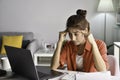 Feeling tired and stressed. Young Asian woman sitting looking exhausted and tired during working at home office using laptop. Royalty Free Stock Photo