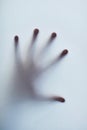 Feeling trapped. Defocussed shot of a single hand reaching out against a plain background. Royalty Free Stock Photo