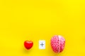 Feelings and mind concept with brain plus heart on yellow background top view mock up