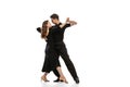 Two young graceful dancers wearing black stage outfits dancing ballroom dance isolated on white background. Concept of Royalty Free Stock Photo