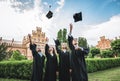 It feels amazing to finally graduate!Four happy college graduates in graduation gowns throwing their mortar boards and smiling Royalty Free Stock Photo