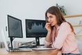 Feels worried. Female stock broker in casual clothes is working in the office by pc Royalty Free Stock Photo