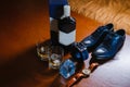 Fees of the groom: men`s shoes, a belt rolled up by a ring, watches, cologne, a bottle of alcohol, two glasses with alcohol and a Royalty Free Stock Photo