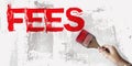 Fees word in red and brush in hand on grunge white grey background. Taxes and fees concept