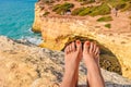 feet against a cliff on the famous Benagil beach in Portugal, waves crashing on the rocks, the raging ocean Royalty Free Stock Photo