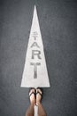 Feet and Arrow on Road of Starting Point. Word Start Written on an Asphalt Concrete with Legs and Shoes. Woman Bare Feet with Gray Royalty Free Stock Photo