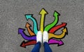 Feet and arrows on road background. Pair of foot standing on tarmac road with colorful graffiti arrow sign choices, creative and