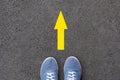 Feet and arrows on road. Direction arrow on asphalt ground, feet and shoes on floor, personal orientation concept Royalty Free Stock Photo