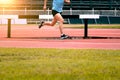 The feet of an athlete running outdoors at the racetrack. Fit young man is running on the race track. Male runner in sportswear Royalty Free Stock Photo