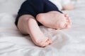 Feet of baby boy on bed. Legs on a white background Royalty Free Stock Photo