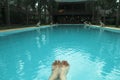 Feet on the background of the blue water of the swimming pool Royalty Free Stock Photo