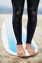 Feet, balance and surfboard with a person on the beach for fitness, recreation or sports training closeup. Legs, sand