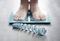 Feet on bathroom scale with tape measure Royalty Free Stock Photo