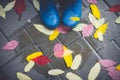 Feet in blue rubber boots standing in a wet concrete paving