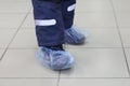 Feet in blue shoe covers. In the photo are two children feet in shoe covers