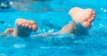 Feet in the blue water of the pool Royalty Free Stock Photo