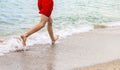 Feet of boy running along the beach Royalty Free Stock Photo