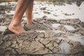 Feet of boy walking on cracked dry ground Royalty Free Stock Photo