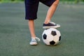 Feet of a child boy with a soccer ball on a green lawn on a football field, sports section, training Royalty Free Stock Photo