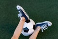 Feet of a child boy with a soccer ball on a green lawn on a football field, sports section, training Royalty Free Stock Photo