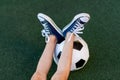 Feet of a child boy with a soccer ball on a green lawn on a football field, sports section, training Royalty Free Stock Photo