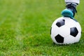 Feet of child on football / soccer ball on grass. Royalty Free Stock Photo