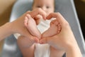 Feet of the child in the hands of the mother in the shape of a heart, close-up. Mother love,maternity leave, motherhood. Royalty Free Stock Photo