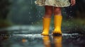 Feet of child in yellow rubber boots jumping over a puddle in the rain Royalty Free Stock Photo