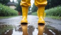 Feet of child in yellow rubber boots jumping over puddle in rain Royalty Free Stock Photo