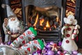 Feet in Christmas socks by the fireplace. Woman relaxes by warm fire and warming up her feet in funny socks. Close up on feet. Royalty Free Stock Photo