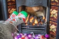 Feet in Christmas socks by the fireplace. Woman relaxes by warm fire and warming up her feet in funny socks. Close up on feet. Royalty Free Stock Photo