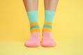 Feet in colorful funny socks in front of yellow studio background