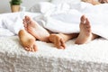 Feet of couple on bed and cross