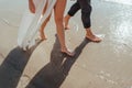 feet of couple. Woman and man in the sea waves on sunset Royalty Free Stock Photo
